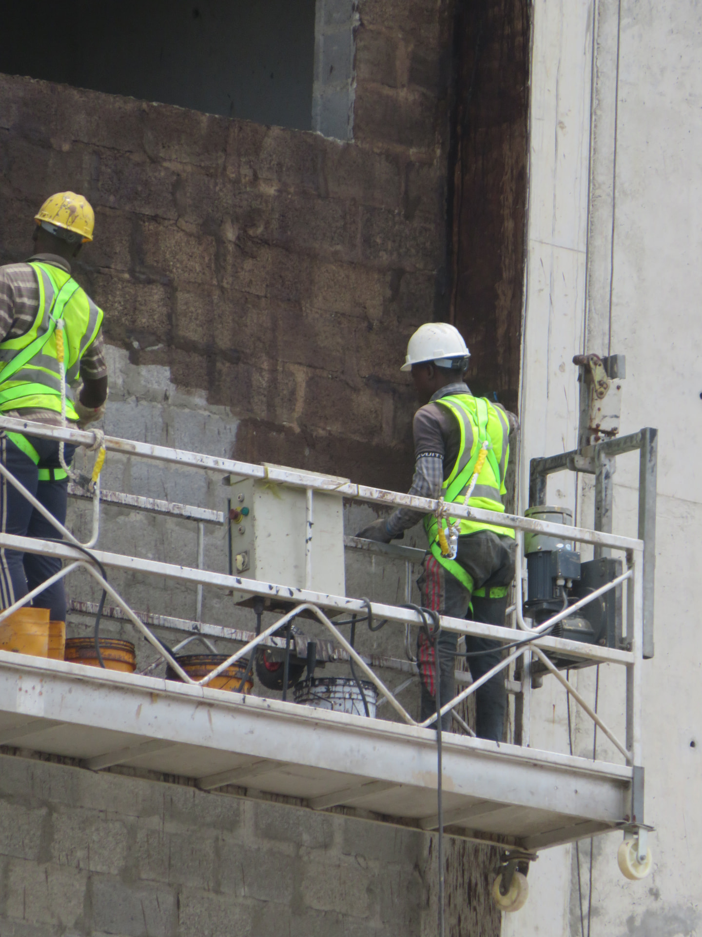 Applicators on a suspended cradle treating an external wall